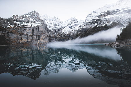 snowy mountains near river during daytime thumbnail