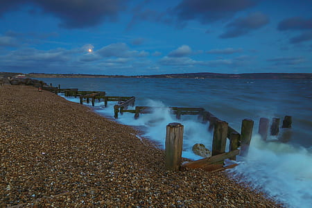 brown wooden fence on water at night time thumbnail