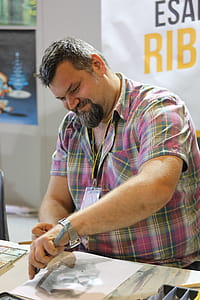 Man Wearing Pink Checkered Shirt While Sketching thumbnail
