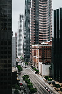 cars on gray road top between concrete buildings during daytime thumbnail