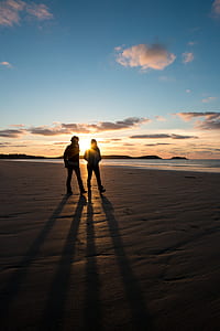 two person walking on seashore during golden hours thumbnail