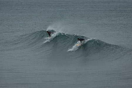 two person surfing on body of water thumbnail