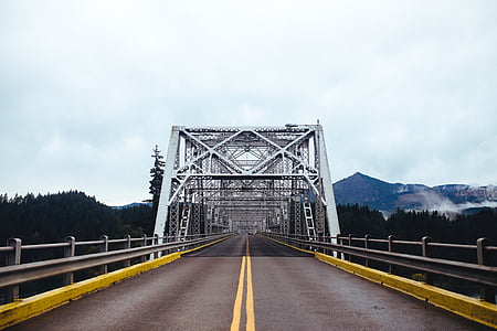 gray bridge between green leafed trees at daytime thumbnail