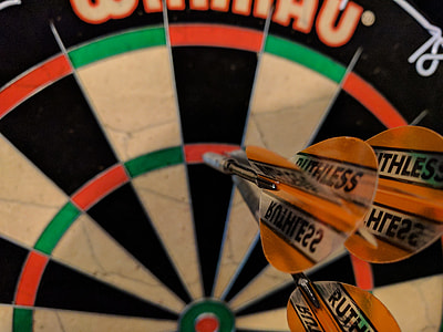 black, green, red, and white dartboard with three arrows thumbnail