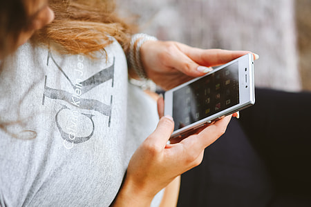 Young woman holding the white mobile phone thumbnail