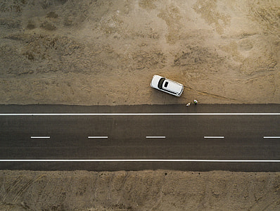 white car parked beside asphalt road during daytime thumbnail