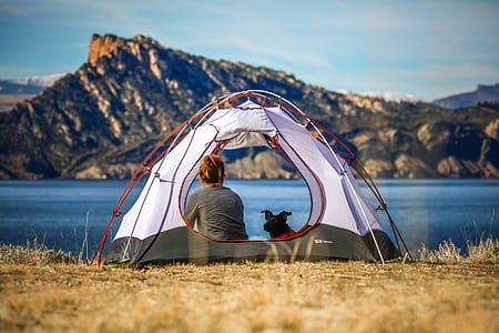 sitting woman inside white and gray tent near water thumbnail