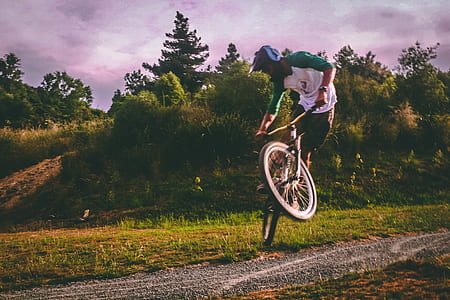 Man in White and Green Raglan Elbow-sleeved Shirt Biking at Daytime thumbnail