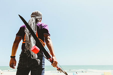 Man Holding Bow in Seashore thumbnail