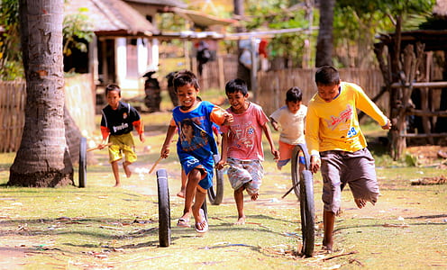 boys playing with black bicycle tires thumbnail