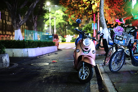 shallow focus photography of silver automatic motor scooter parked beside pavement thumbnail