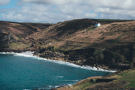 white structure on hill and sea thumbnail