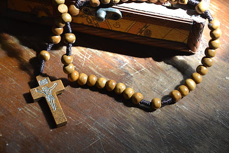 brown rosary on brown wooden board thumbnail