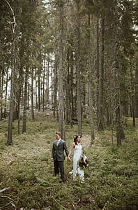 couple holding hands while standing on nature at daytime thumbnail