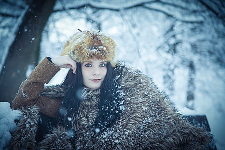 woman sitting on bench under snow thumbnail