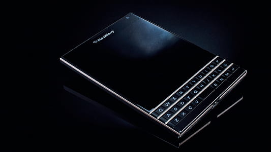 black BlackBerry smartphone on black table thumbnail
