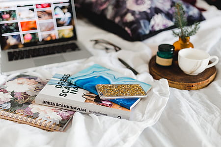 Bed full of pillows and notebooks with Apple gadgets thumbnail