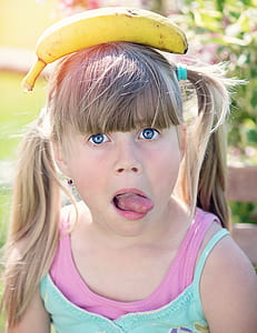 selective focus photography of banana on girl head thumbnail