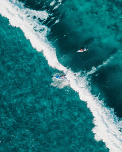 aerial photography of two person surfing during daytime thumbnail