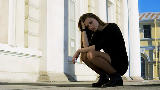 woman holding her hair while squatting thumbnail