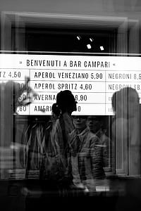 grayscale photo of man standing near clear glass panel thumbnail