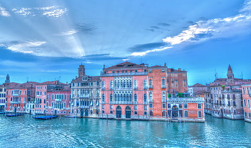 brown buildings beside body of water under blue sky thumbnail