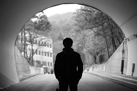 silhouette photo of man standing in tunnel thumbnail
