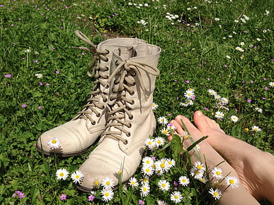 pair of white boots on plants with white flowers thumbnail