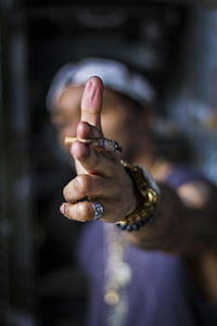 selective focus photo of man holding brown cigarette butt thumbnail