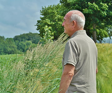 man wearing gray polo shirt surrounded by grass thumbnail