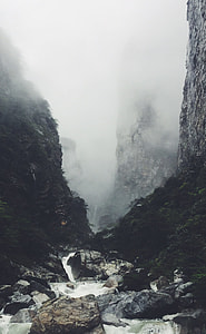 rocky river between cliffs during foggy weather thumbnail
