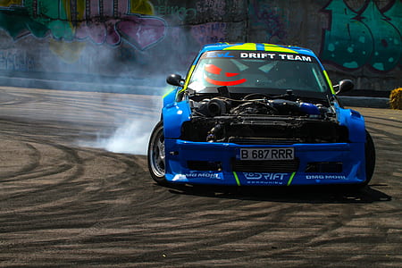 blue and yellow racing car on gray racing trach thumbnail