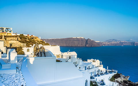 white concrete structure near ocean and mountain thumbnail