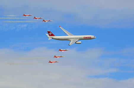 white and red Swiss airliners during daytime thumbnail