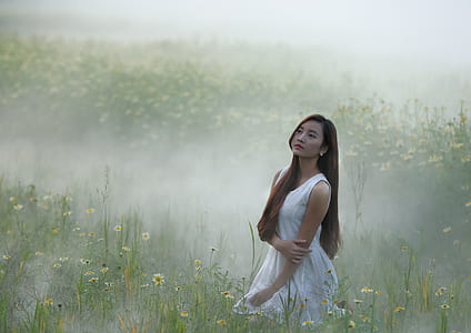 woman wearing dress near bed of petaled flower thumbnail