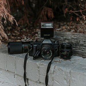 black Canon DSLR camera with lens on gray cinder blocks thumbnail