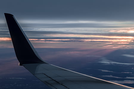 black and gray airplane wing with view of cloudy horizon thumbnail