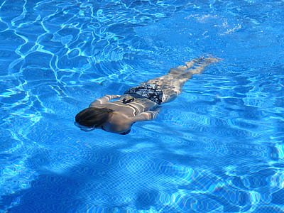 woman wearing bikini swimming on pool during daytime thumbnail