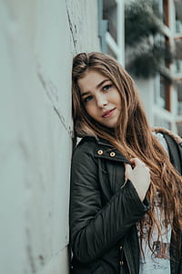 woman leaning on gray wall thumbnail