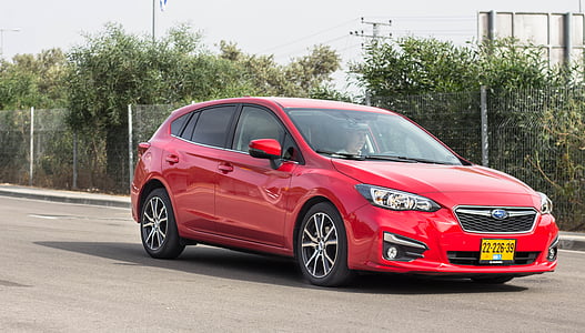 red Subaru 5-door hatchback on roadway thumbnail