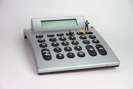 four figurines on turned off calculator thumbnail