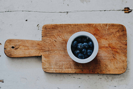 photo of white ceramic cup on brown wooden chopping board thumbnail