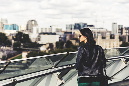 A woman wearing a leather jacket and sunglasses looks out across the City of London. Image captured with a Canon 6D thumbnail