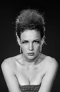 grayscale photography of woman against black background thumbnail