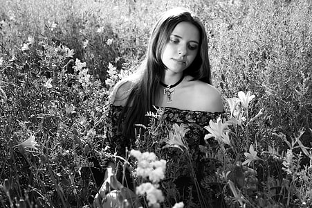 grayscale photo of woman wearing off-shoulder shirt and choker standing on flower field thumbnail
