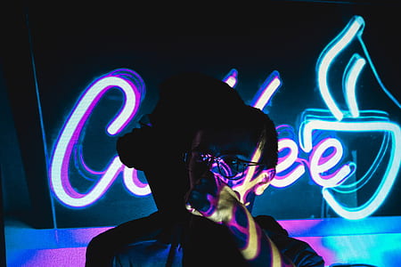 person drinking near purple neon signage thumbnail