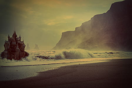 castle on body of water beside mountain thumbnail