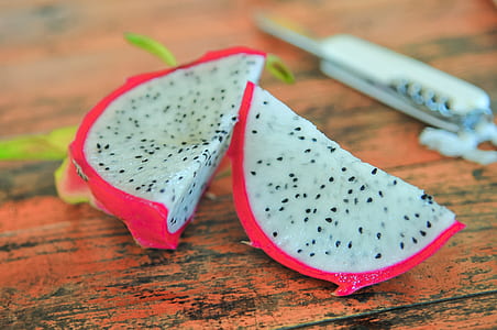 sliced pitaya fruit placed on brown wood thumbnail
