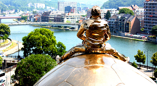 man sitting on turtle statue thumbnail