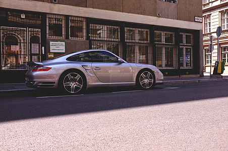 silver Porsche 911 coupe parked near concrete building during daytime thumbnail